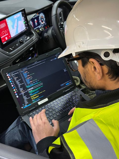 Member of Auriga team using a laptop in a car setting up digital mapping.