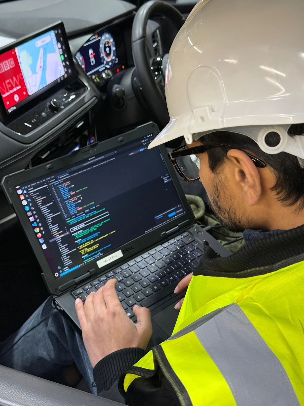 Member of Auriga team using a laptop in a car setting up digital mapping.